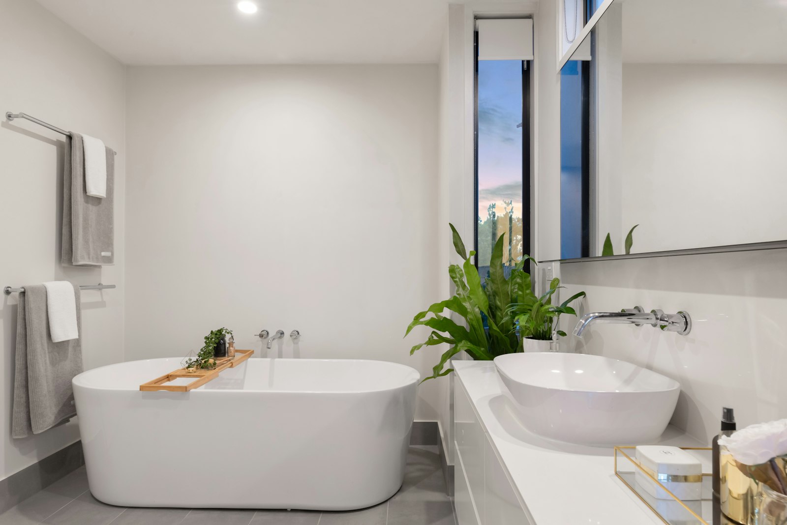 A sparkling clean bathroom with a gleaming bath and large window